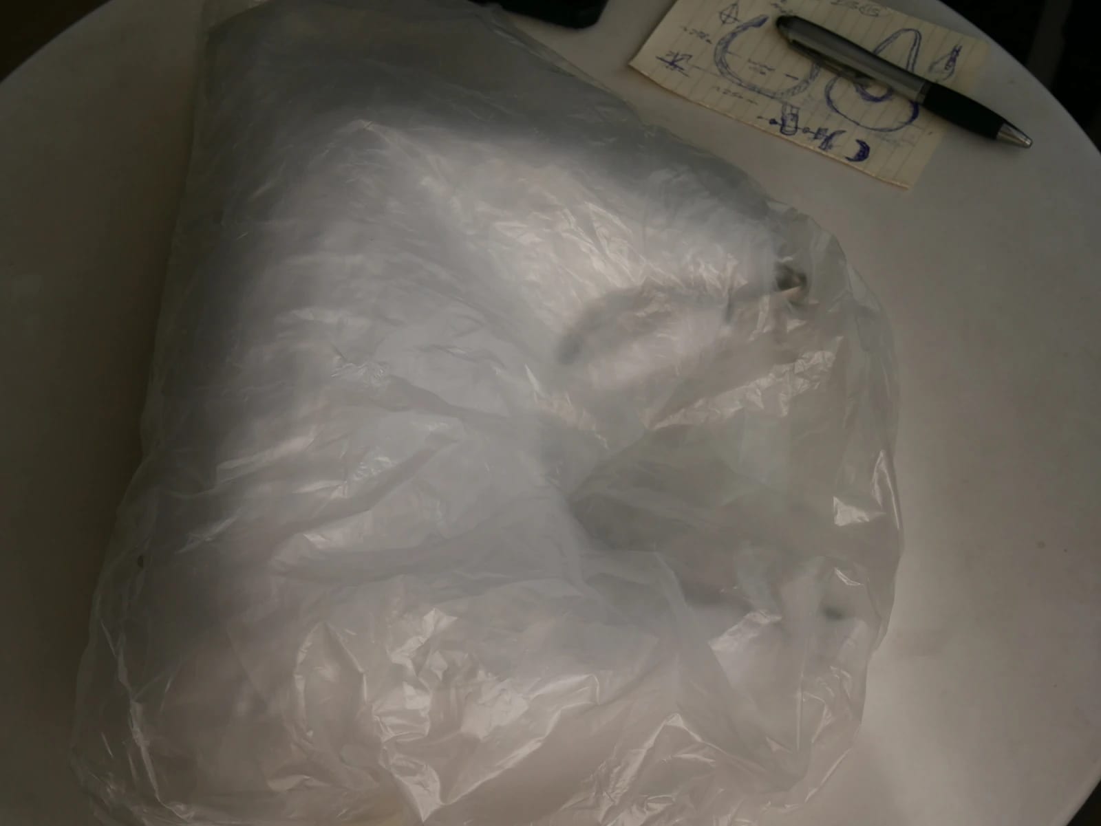 The earlier working version under translucent wrapping, with the sketch and the pen
