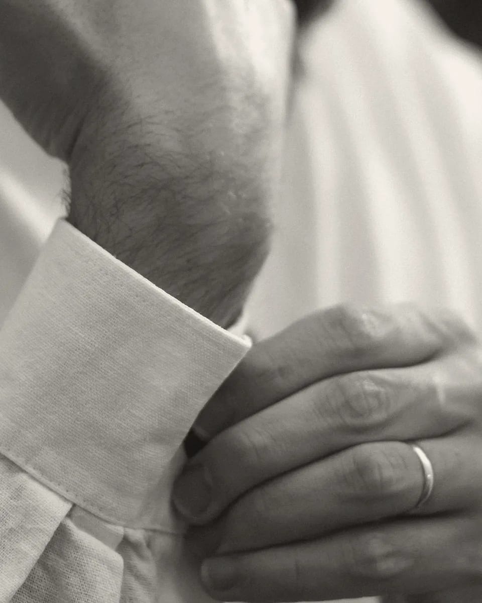 A hand fastening a shirt cuff
