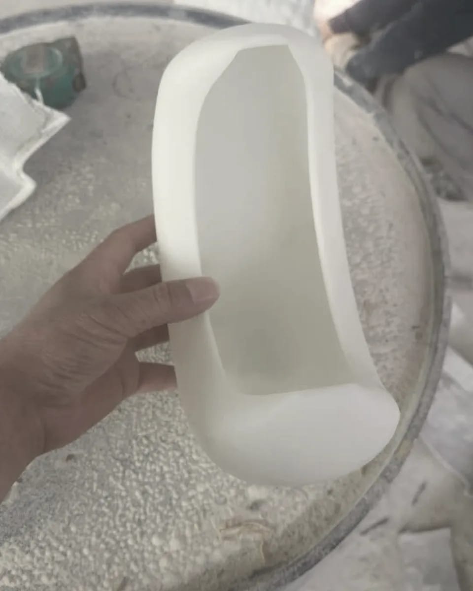 A hand holding a PORTALE shell at the atelier