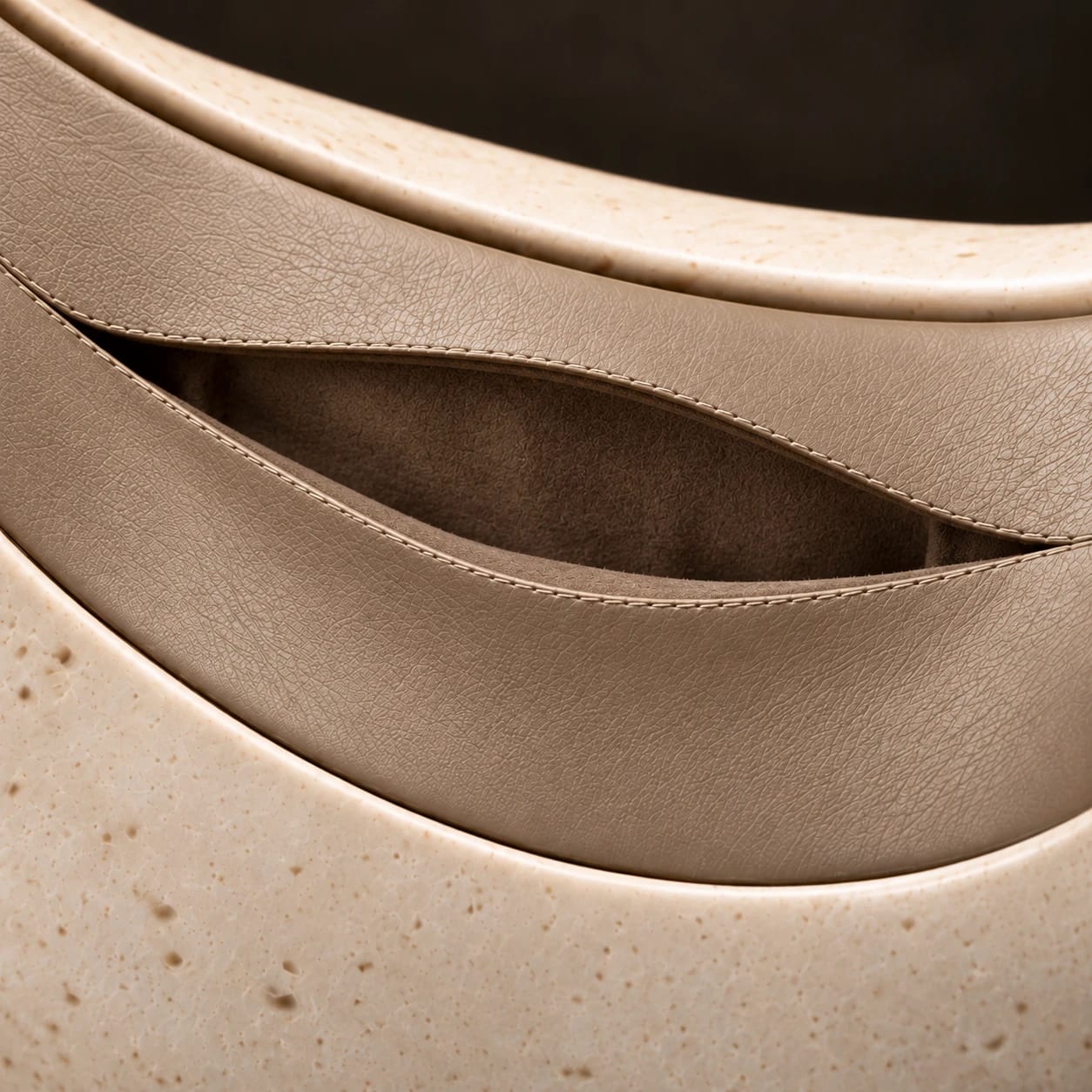 Two slightly parted taupe leather edges reveal PORTALE’s interior lining