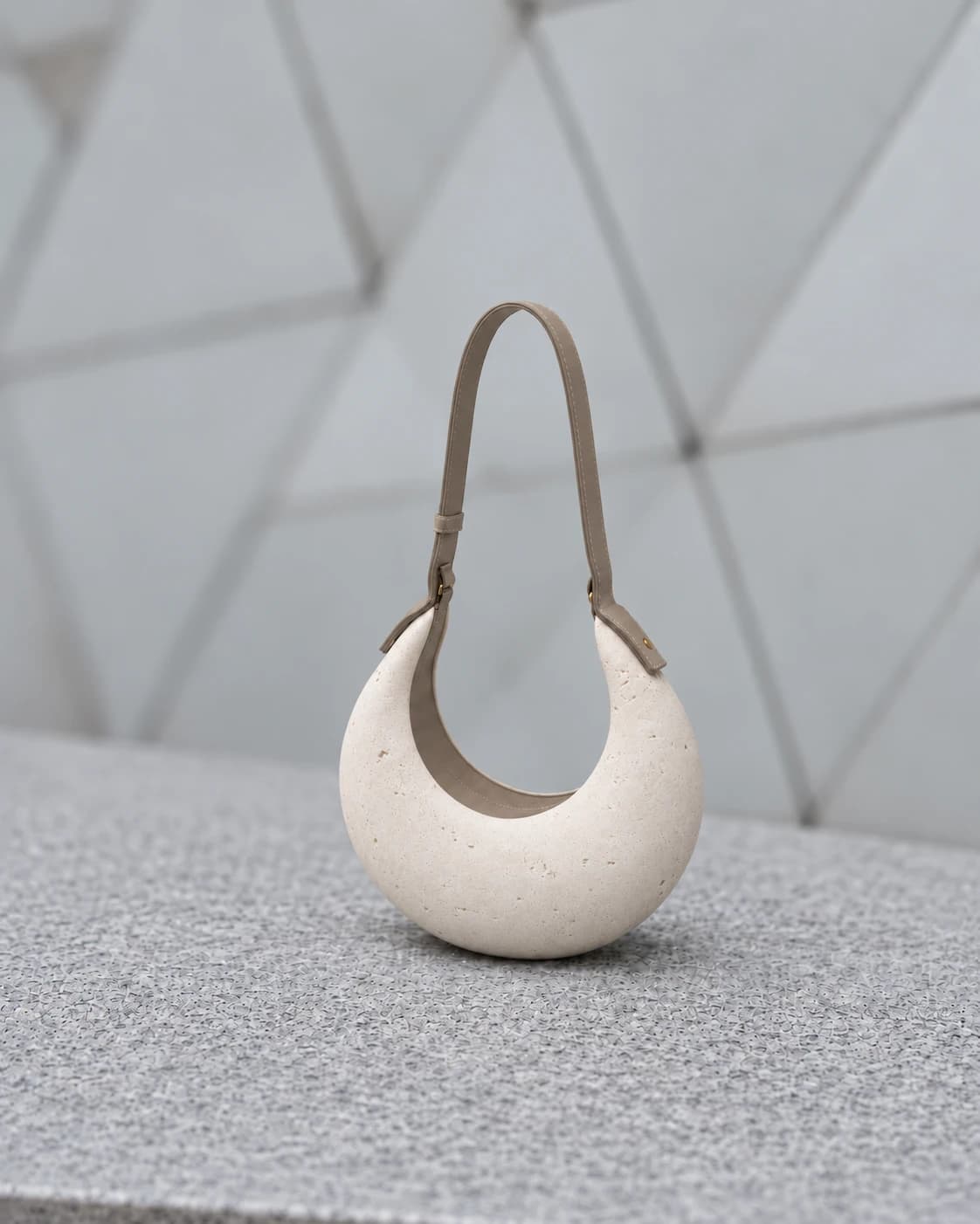 PORTALE resting alone on a granite bench, before a faceted stone wall