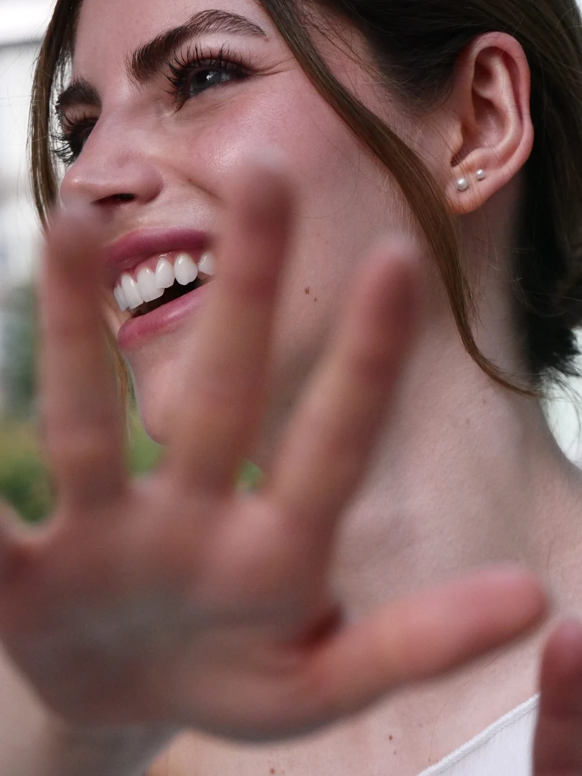 Valentina smiling with her hand in front of the lens between takes.