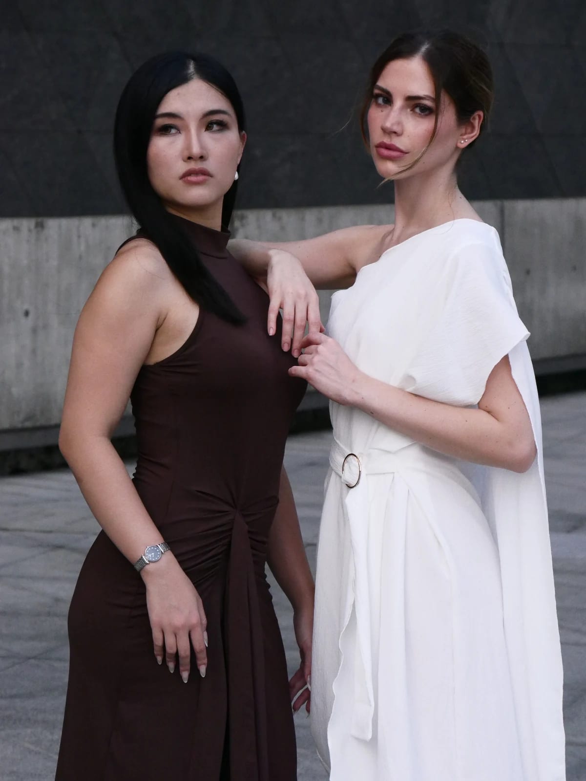 Valentina and Elodie pose together in white and brown dresses.