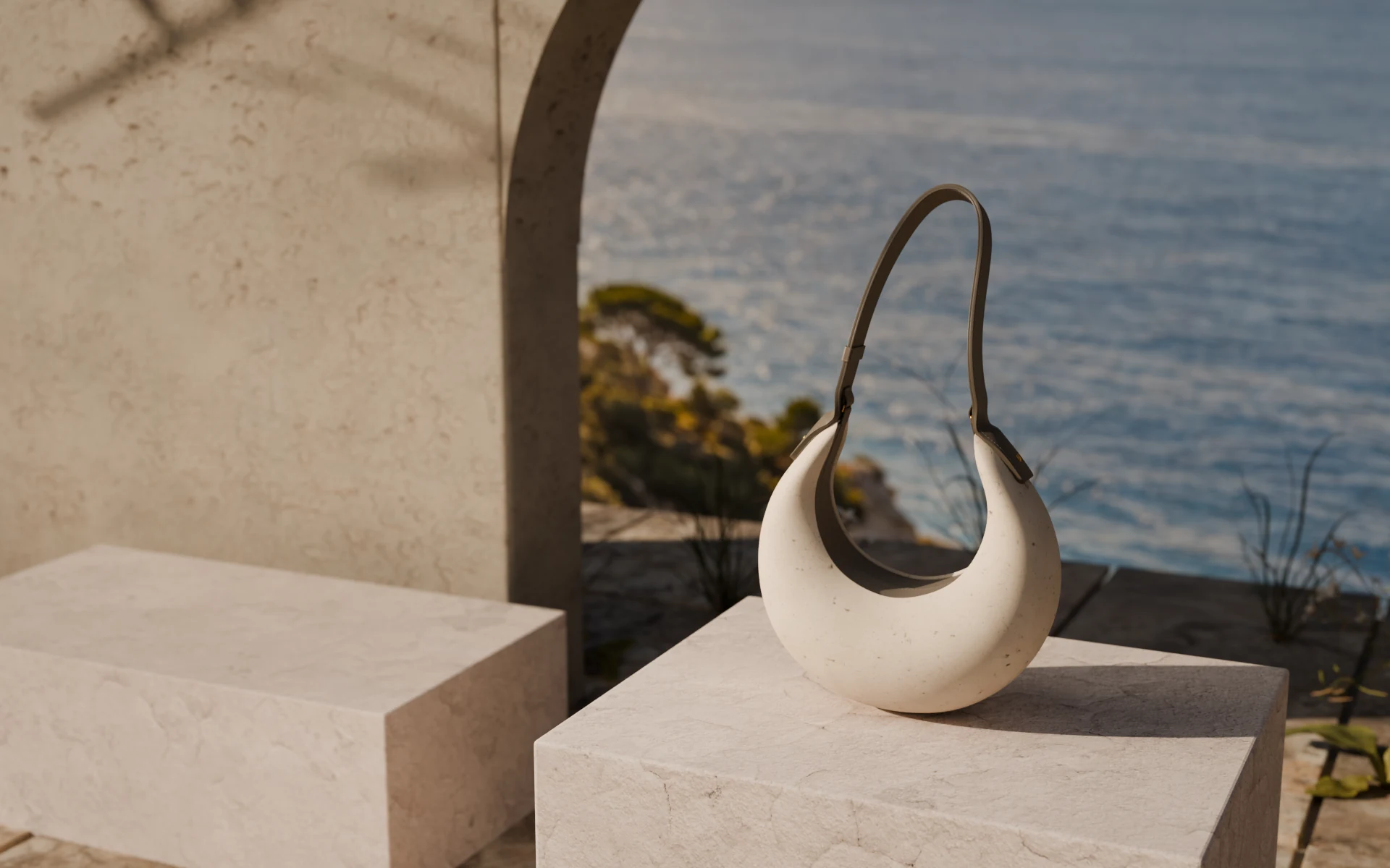 PORTALE, an ivory mineral shell and taupe leather handle, on a stone plinth